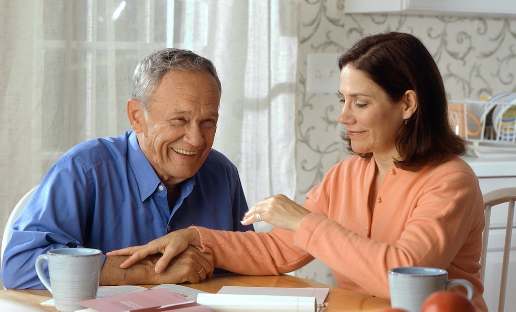 Middle-aged woman having a conversation with her smiling father.
